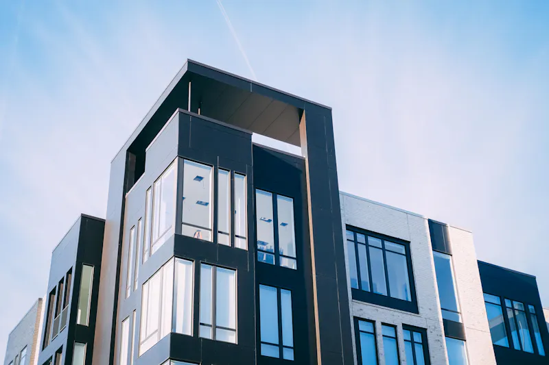 Immeuble neuf à façade noire et grandes fenêtres